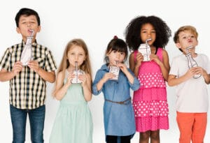 A child drinking a glass of water, promoting healthy beverage choices for strong teeth and overall health