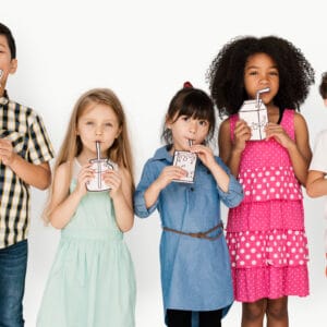 A child drinking a glass of water, promoting healthy beverage choices for strong teeth and overall health